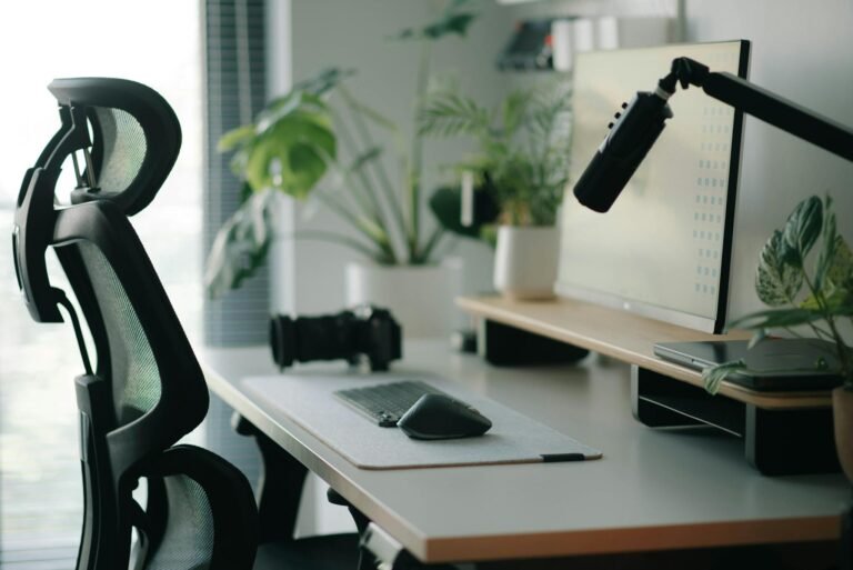 Stylish home office setup with ergonomic chair, plants, and tech accessories creating a modern work environment.